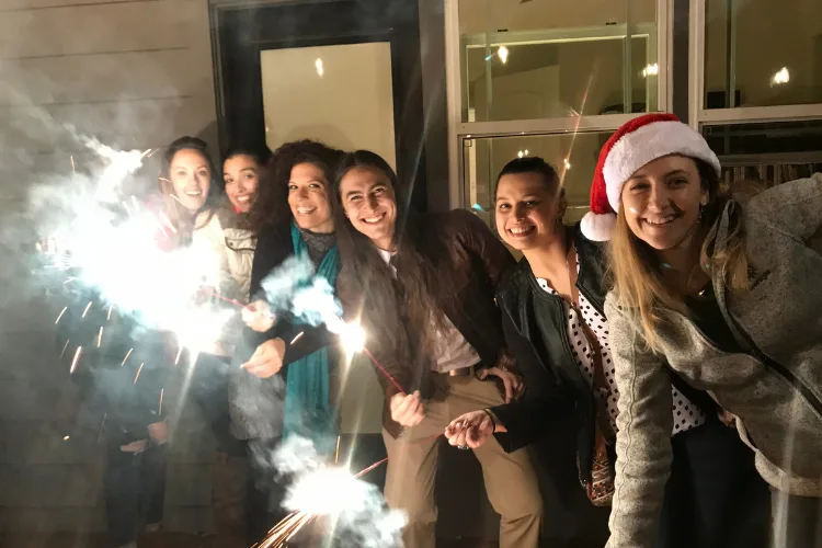 Remote team members celebrating holidays together via video call with festive decorations